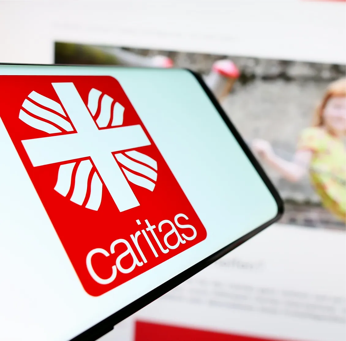 Caritas logo on a smartphone screen